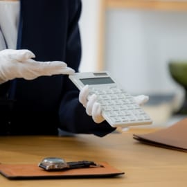 白手袋を着用した査定士が電卓を使い、価格を提示している様子