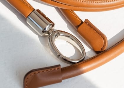 キャメルブラウンのレザー製ストラップとシルバーの金具が付いた高級感のあるデザイン